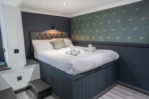 a bedroom with a large bed with white pillows at Sutherland mini apartments in Fort William