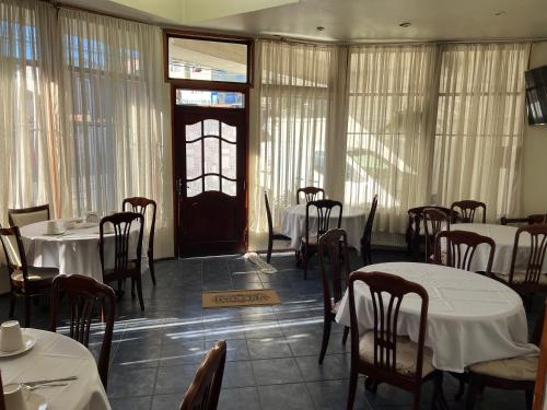 a dining room with tables and chairs and a door at Altos de Miramar in Puerto Montt