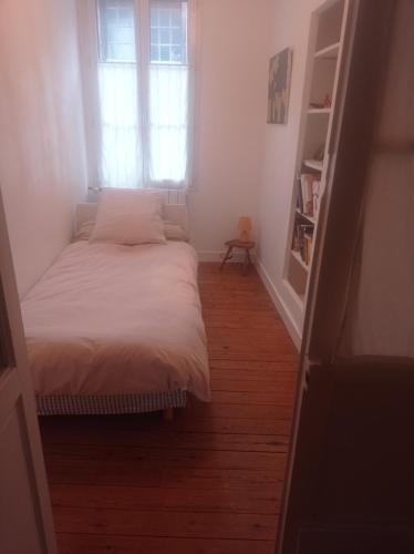 a small bedroom with a bed and a window at La maison de Nina in Pont-Sainte-Maxence