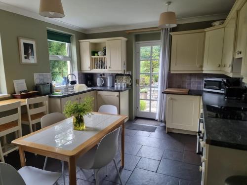 eine Küche mit einem Tisch und Stühlen darin in der Unterkunft Cosy Cottage overlooking the Teifi Gorge in Cilgerran
