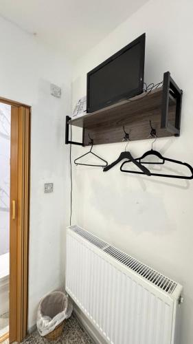 a flat screen tv on a shelf above a radiator at Earl's Court Rooms in London