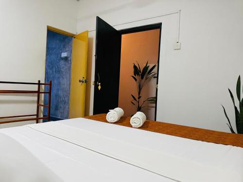 a bedroom with a white bed with two white towels at Solo's Shelter Hostel Udawalawa in Udawalawe