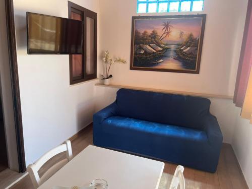 a blue couch in a living room with a table at Madomare Case al Mare in Lampedusa