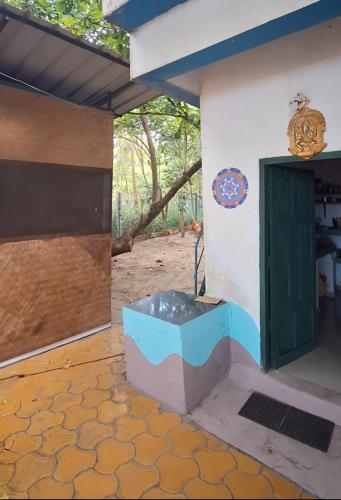 a room with a tub in the side of a house at Marari Beach Bamboo Rooms AcroYogaThai in Alleppey