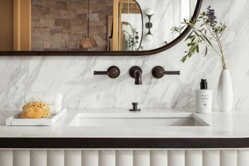 a bathroom with a white sink and a mirror at One&Only Aesthesis, Athens in Athens