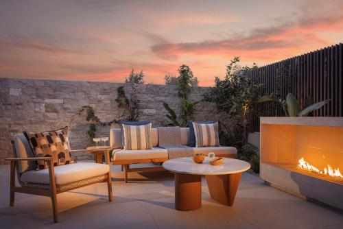 a patio with a couch and chairs and a fireplace at One&Only Aesthesis, Athens in Athens