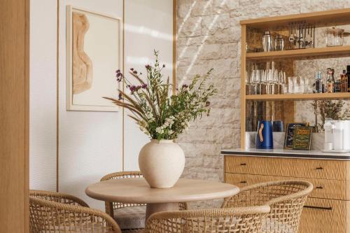 a table with a vase with flowers on it at One&Only Aesthesis, Athens in Athens