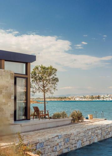 a building with a bench next to the water at One&Only Aesthesis, Athens in Athens