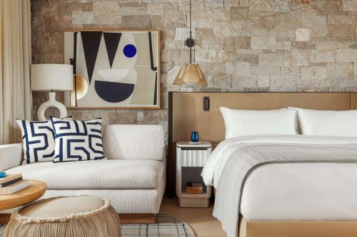 a hotel room with a bed and a couch at One&Only Aesthesis, Athens in Athens