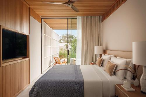 a bedroom with a large bed and a large window at One&Only Aesthesis, Athens in Athens