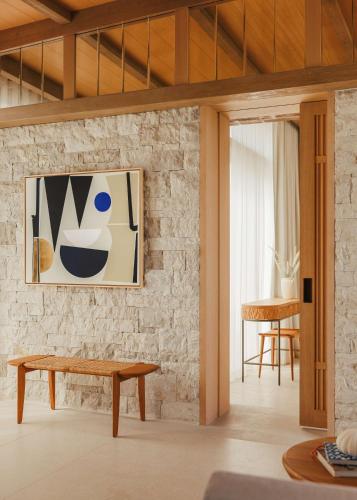 a living room with a bench and a painting on a brick wall at One&Only Aesthesis, Athens in Athens