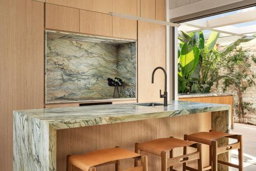 a kitchen with a marble counter top and stools at One&Only Aesthesis, Athens in Athens