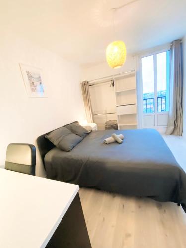 une chambre avec un grand lit et un canapé dans l'établissement Appartement Suzon - Résidence Le Voltaire - Talence - Tram B - WIFI - REF F2, à Talence