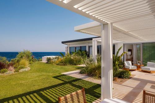 a porch of a house with a view of the ocean at One&Only Aesthesis, Athens in Athens