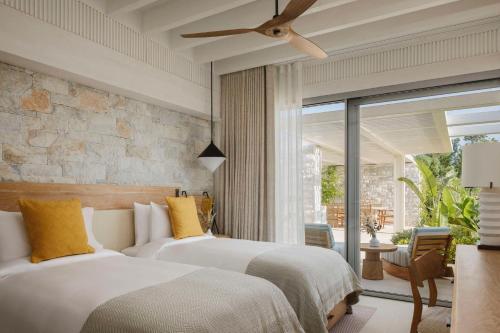 two beds in a hotel room with a patio at One&Only Aesthesis, Athens in Athens