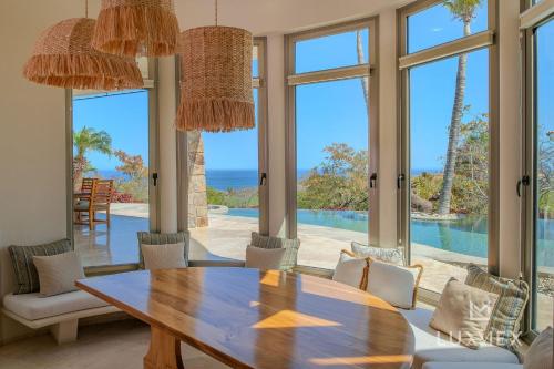 a dining room with a table and a view of the ocean at Spacious 5 Bd Villa Fully Staffed w Chauffeur in Puerto Los Cabos! in San José del Cabo