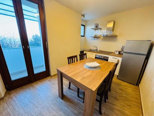 a kitchen with a wooden table and a refrigerator at Appartamenti Sogno Alice Bel Colle in Alice Bel Colle