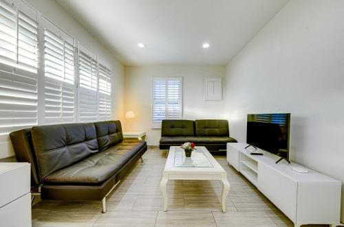 a living room with a couch and a tv at Stylish Modern Home, AC, Parking & Near FWYs in Santa Ana