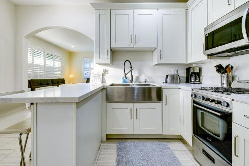 a kitchen with white cabinets and a sink at Stylish Modern Home, AC, Parking & Near FWYs in Santa Ana