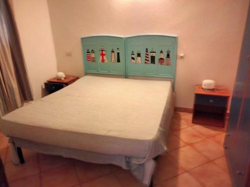 Villa Smeralda Costa Paradiso Sardinia holidays في كوستا باراديسو: سرير في غرفة مع زجاجات على الحائط