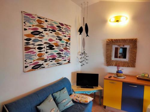 Villa Smeralda Costa Paradiso Sardinia holidays في كوستا باراديسو: غرفة معيشة مع أريكة زرقاء ولوحة على الحائط