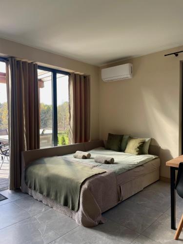 a bedroom with a large bed in front of a window at Natura Home in Skoki