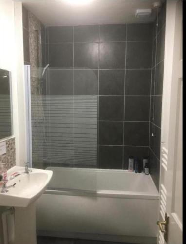 a bathroom with a tub and a sink and a bath tub at Toasty & Warm Beds in Dundee