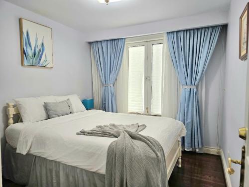a bedroom with a large bed with blue curtains at A Home Away-Deluxe Guest Room in Toronto in Toronto
