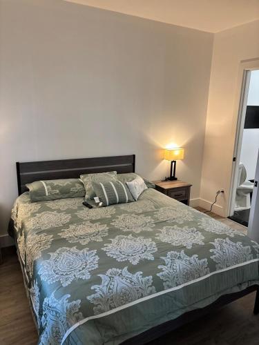 a bedroom with a bed with a green bedspread at Sweet getaway 6 min from EWR in Elizabeth