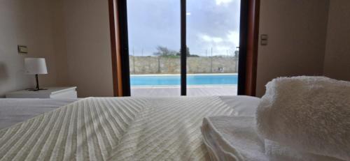 a bedroom with a bed with a view of a pool at Petit Maison in Além da Ribeira