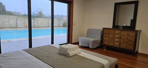 a bedroom with a bed and a dresser and a pool at Petit Maison in Além da Ribeira