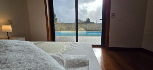 a bedroom with a bed and a view of a swimming pool at Petit Maison in Além da Ribeira