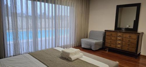 a bedroom with a bed and a dresser and a mirror at Petit Maison in Além da Ribeira