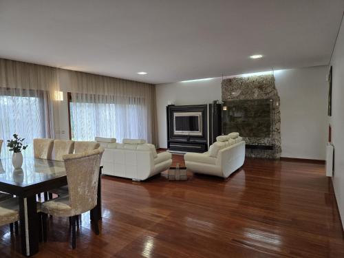 a living room with white furniture and a fireplace at Petit Maison in Além da Ribeira