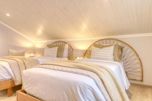 two beds in a room with white walls at Casa da Praia, a Home in Madeira in Tábua