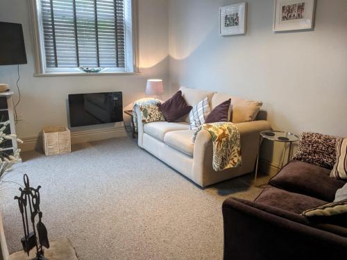 ein Wohnzimmer mit Sofa und Fernseher in der Unterkunft 1 Hillside Cottages in Leeds