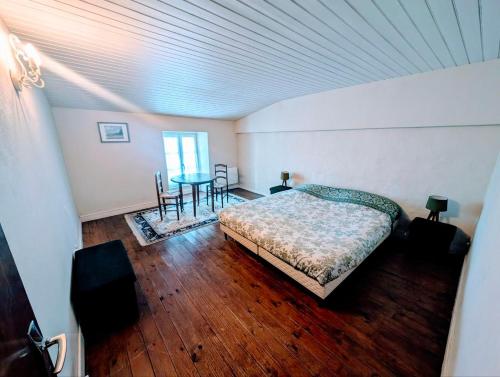 une chambre avec un lit, une table et des chaises dans l'établissement Maison de village classé petite cité de caractère, à Foussais