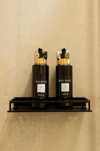 two bottles of soap sitting on a shelf at RUSS0 ROOMS Catanzaro in Catanzaro