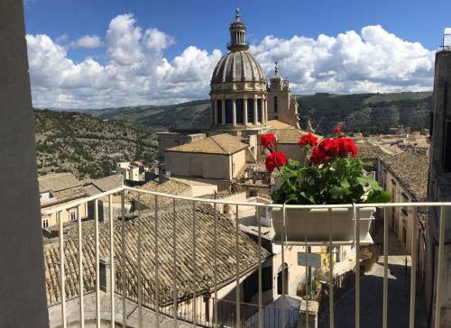 a vase with red flowers on top of a building at Il Duomo Relais in Ragusa