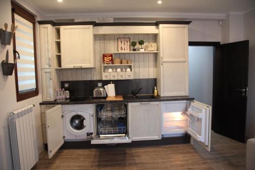 ドブリチにあるApartment Retroのキッチン(白いキャビネット、洗濯機、乾燥機付)