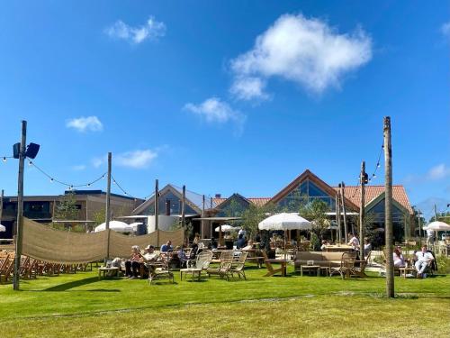 un grupo de personas sentadas en sillas en la hierba en Holiday home close to beach, en Noordwijkerhout