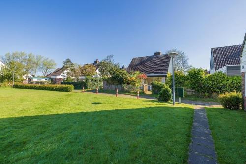 a grassy yard with a street light and houses at Holiday home close to beach and Keukenhof in Noordwijkerhout