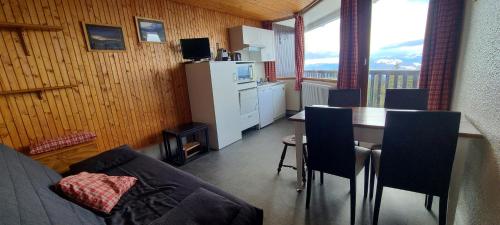 - un salon avec une cuisine et une table avec des chaises dans l'établissement Appartement 4 personnes 30 m² Station Chamrousse, pied des pistes, à Chamrousse