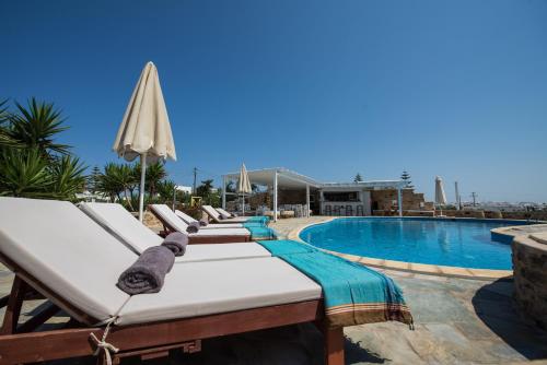 a row of beds next to a swimming pool at Kastro Antiparos in Antiparos