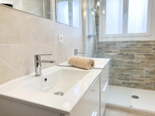 une salle de bain blanche avec un lavabo et une douche dans l'établissement La parenthèse partagée, à Brest