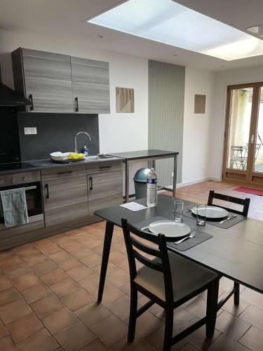 une cuisine avec une table et deux chaises ainsi qu'une salle à manger dans l'établissement Appartement Duo Valenciennes, à Marly