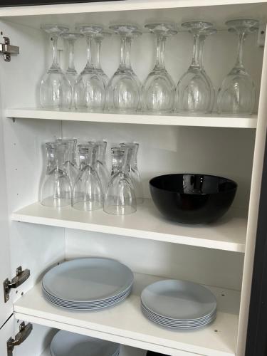 a shelf with wine glasses and plates on it at MOREaccom Maisonette in Morecambe