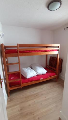 Ce dortoir comprend 2 lits superposés et des draps rouges. dans l'établissement Appartement 4 personnes, au pied des pistes de l'espace Diamant, à Flumet
