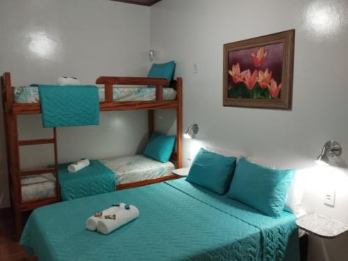 a bedroom with two bunk beds with blue sheets at Pousada Baía do Sol Saquarema in Saquarema