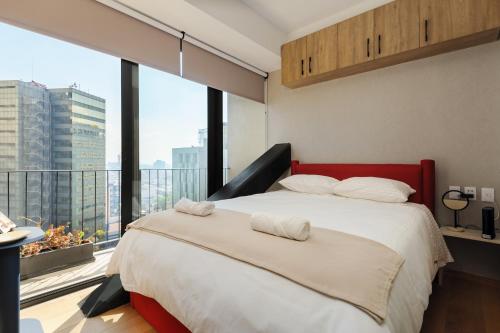 a bedroom with a large bed and a large window at Casa Colon in Mexico City